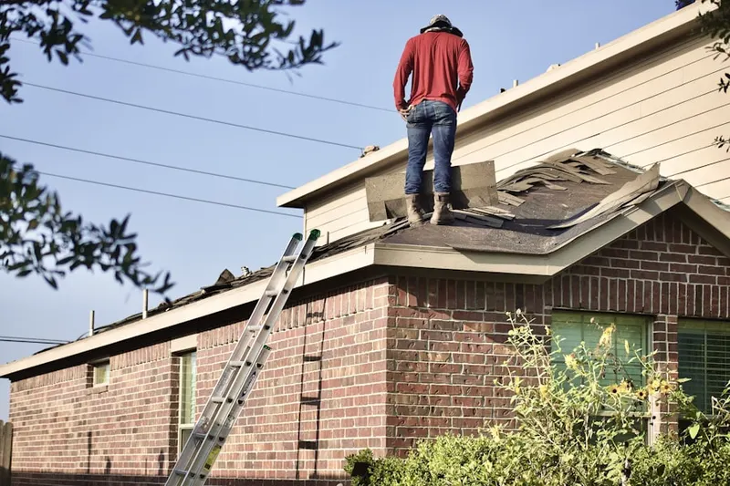 Professional roofer working on a residential roof in Hall